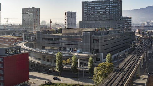 Moderne Stadtansicht mit Bürogebäuden und Bahngleisen.